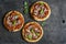 Mini salami pizza on a dark wooden background