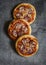 Mini salami pizza on a dark wooden background