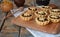 Mini Tartlets with dried Fruits and nuts. Shortbread cookies with fruits stuffing on wooden background. Small sweet pie. Copy
