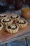 Mini Tartlets with dried Fruits and nuts. Shortbread cookies with fruits stuffing on wooden background. Small sweet pie. Copy