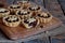 Mini Tartlets with dried Fruits and nuts. Shortbread cookies with fruits stuffing on wooden background. Small sweet pie. Copy