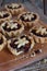 Mini Tartlets with dried Fruits and nuts. Shortbread cookies with fruits stuffing on wooden background. Small sweet pie. Copy