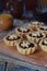 Mini Tartlets with dried fruits and nuts. Shortbread cookies with fruits stuffing on wooden background. Small sweet pie. Copy