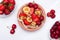 Mini tiny pancakes with straeberries and cherries on white wooden background. Trendy food concept. Flat lay