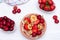 Mini tiny pancakes with straeberries and cherries on white wooden background. Trendy food concept. Flat lay