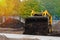 Mini tractor pours the soil out of the bucket, yellow excavator at work