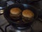 Mini veggie hamburgers being heated up in a frying pan.