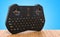 Mini Wireless Bluetooth Keyboard on the wooden table, 3D rendering