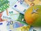 Miniature airplane on mango with euro banknotes on background, concept of the costs of exotic fruit import