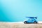 Miniature blue car with surfboard