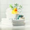 A miniature bubble bath, yellow rubber duck and white towels on bathroom countertop, children bath accessories, baby