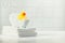 A miniature bubble bath, yellow rubber duck and white towels on bathroom countertop, children bath accessories, baby