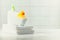 A miniature bubble bath yellow rubber duck and white towels on bathroom countertop, children bath accessories, baby care