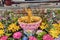 Miniature Buddha standing in bowl of water surrounded by colorful flowers