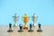 Miniature business concept - businessman lineup rank with golden trophy in the middle