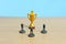 Miniature business concept - businessman lineup rank with golden trophy in the middle