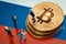 Miniature businessman figurines standing near the pile of shiny golden bitcoin on Russia flag