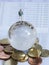 Miniature businessman stand on globe of glass, Euro coins and bo