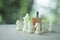 Miniature businessman standing on wooden block above white chess. Strategic concept