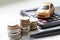 Miniature car model, coins stack, calculator and saving account book or financial statement on office desk table