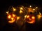 Miniature carved halloween pumpkin illuminated by led light chain, autumn decoration in the evening darkness