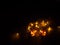 Miniature carved halloween pumpkin illuminated by led light chain, autumn decoration in the evening darkness
