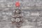 Miniature christmas tree made of pine cones and lollipop on gray