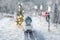 Miniature classic car carrying a christmas tree on on snowy road in winter