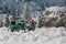 Miniature classic car carrying a christmas tree on snowy winter landscape