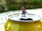 Miniature cleaning lady carrying heavy bucket on top of soda can