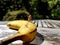 Miniature cleaning lady cleaning banana outside on wooden table