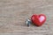 Miniature couple with red heart love symbol on wooden table, hus