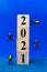 Miniature divers diving around wooden block 2021 , Happy new Year concept