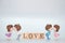 The Miniature doll of couple boy and girl kiss and have Wooden alphabet word LOVE isolate on White background