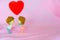 The Miniature dolls of couple boy and girl kiss and have big red heart on above with pink background for Valentine`s Concept