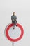 Miniature figurine of a business man sitting on a denied access sign