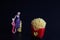 Miniature figurine of a mother with her children looking at french fries on a black background