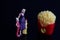 Miniature figurine of a mother with her children looking at french fries on a black background