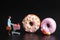 Miniature figurine of a woman with a supermarket cart shopping some giant donuts