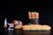 Miniature figurine of a woman with a supermarket cart shopping some giant loaves of bread on a black background