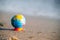 A miniature globe lies on the sand. The concept of dreams about travel and plans for the future.