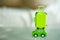 Miniature green travel suitcase on wooden green car