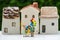 Miniature happy family holding balloons with ceramic house as pr