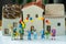 Miniature happy family holding balloons with ceramic house as pr