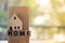 Miniature home put on cube blocks spelling `HOME`