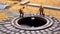 Miniature human toys toiling on a manhole, maintaining the city\\\'s infrastructure and functions