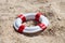 Miniature lifebuoy on sand