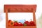 Miniature market stall with vegetables and fruits, blurred background