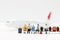 Miniature people with baggage waiting for airplane. Transportation, traveling or business trip concepts.
