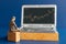 Miniature people, Business people and laptop featuring stock tickers